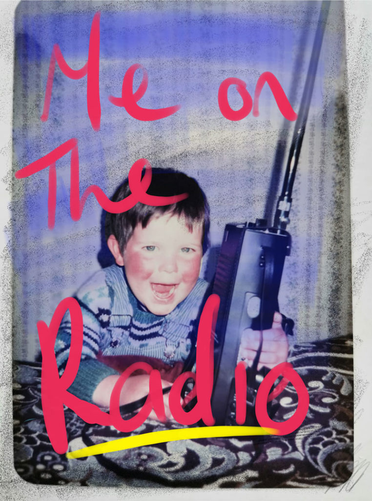 A small ruddy-faced boy holding a massive CB radio and grinning maniacally